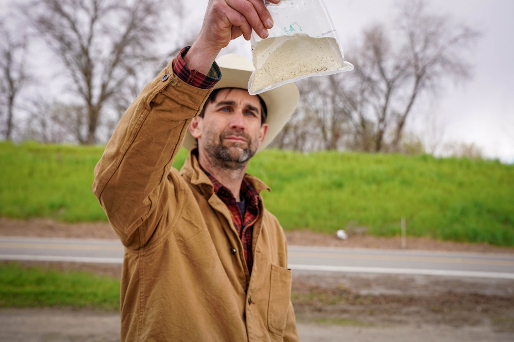 A scientist holds a bag of bugs.