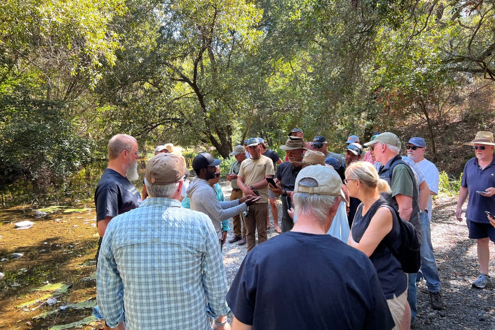 Volunteers attend a training on the banks of the creek