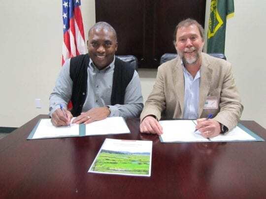 Barnie Gyant (Forest Service Deputy Regional Forester) and Mark Drew (Sierra Headwaters Program Director for California Trout) signing MOU agreement.